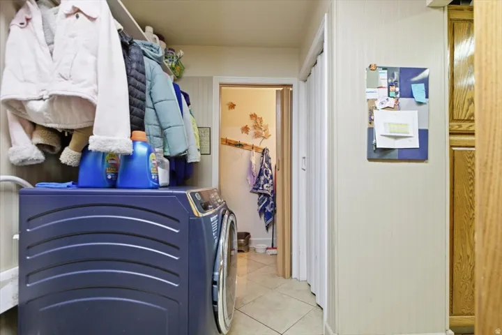Built-in shelving and storage, wood-finish cabinetry, neutral wall covering, and tiled flooring