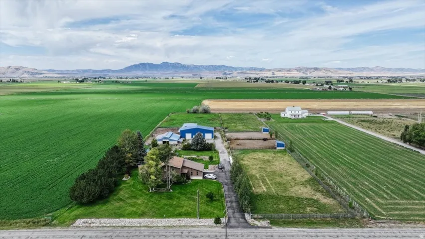Expansive property with multiple structures, including a primary residence and a large blue agricultural building