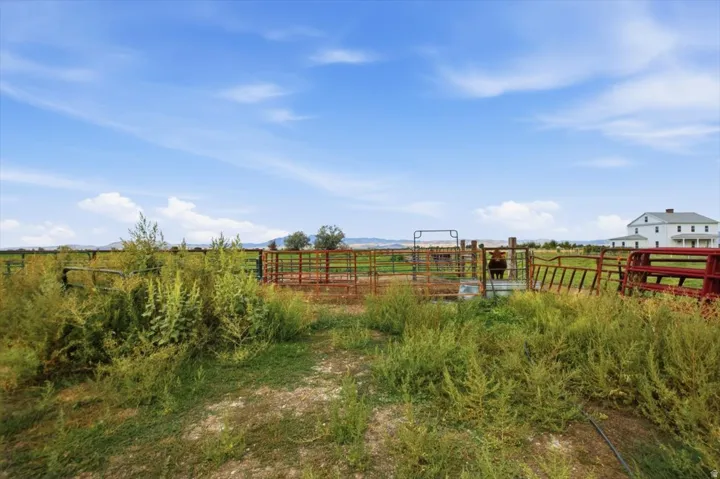 Expansive open fields with perimeter fencing and distant mountain ranges