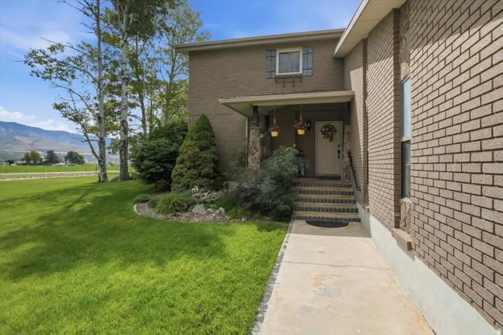 Brick exterior with a covered entry, stone accents, and a concrete walkway