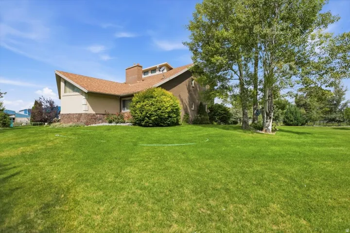Expansive green lawn with mature trees and a distinctive roofline