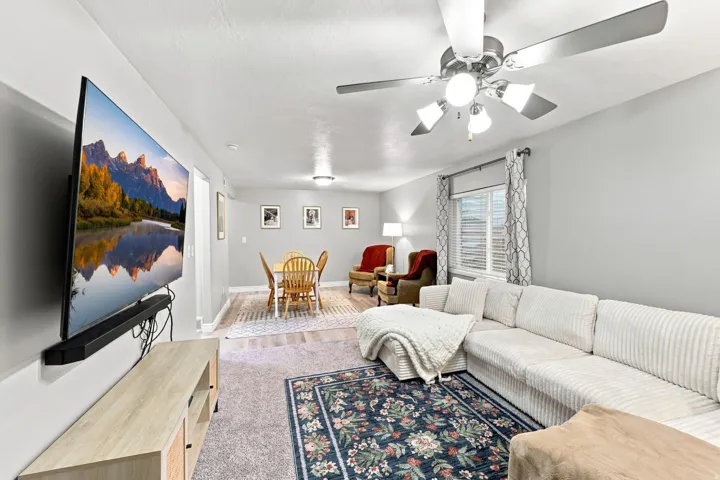 Recessed lighting, wood-finish flooring, ceiling fan with integrated lighting, window with blinds, and light gray wall paint