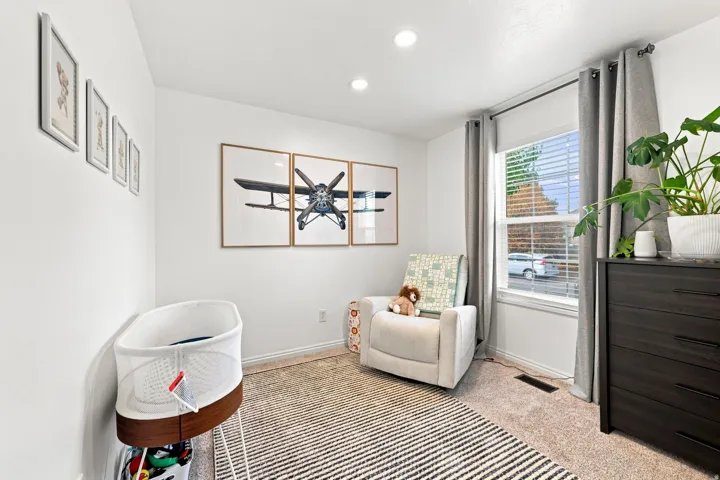 White walls, recessed lighting, and a window with blinds