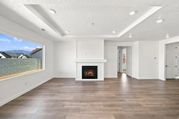 Recessed lighting, a tray ceiling, and a fireplace with a mantel