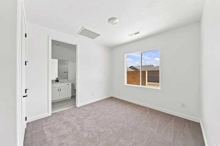 Casita BedroomNeutral-toned carpeting and white walls in this room with a single window