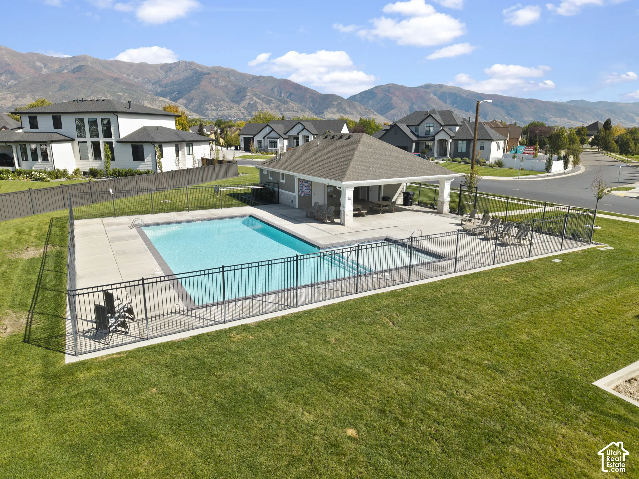 Community swimming pool with a covered pavilion and surrounding concrete deck