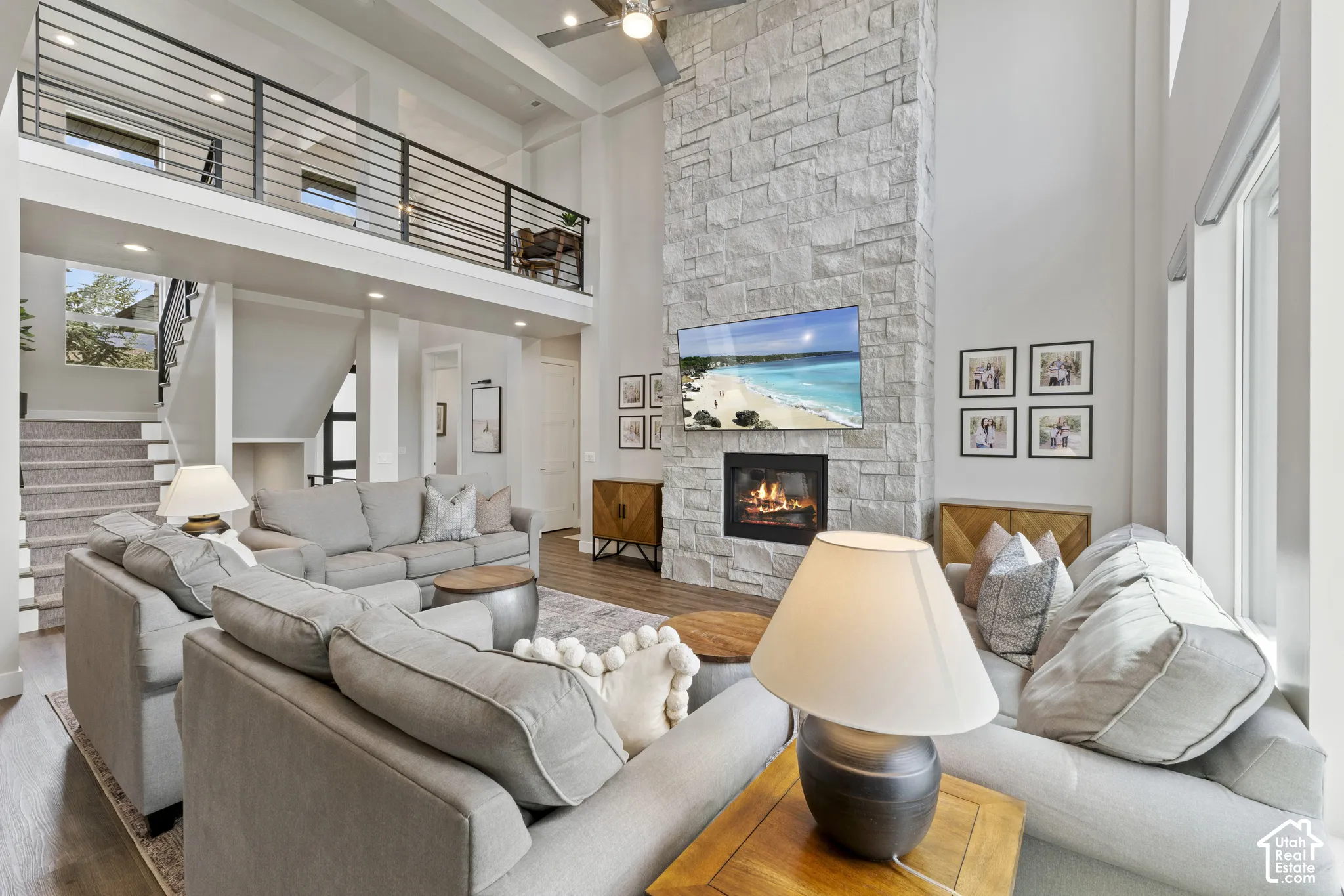 Soaring two-story great room with white shiplap ceiling and recessed lighting, anchored by a linear gas fireplace with stone surround