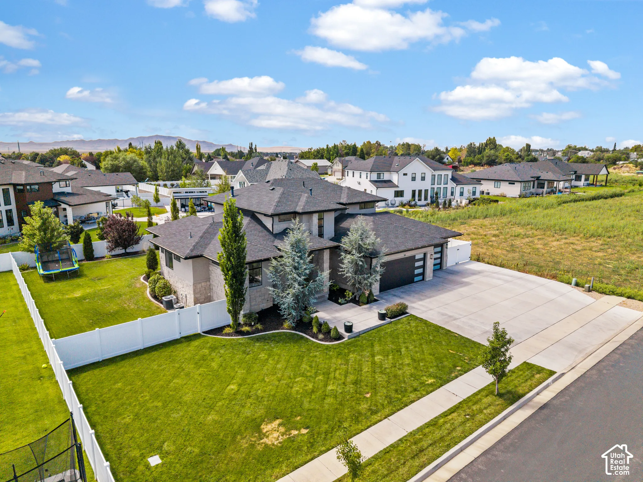 Modern two-story residence showcasing a contemporary exterior with dark architectural accents, situated on an expansive manicured lawn with mature landscaping