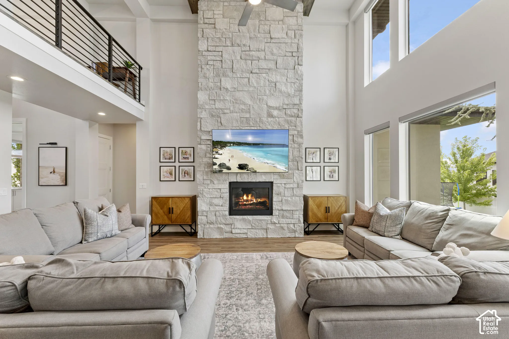 Soaring two-story living room anchored by a floor-to-ceiling stacked stone fireplace with integrated electric fireplace insert and built-in media niche