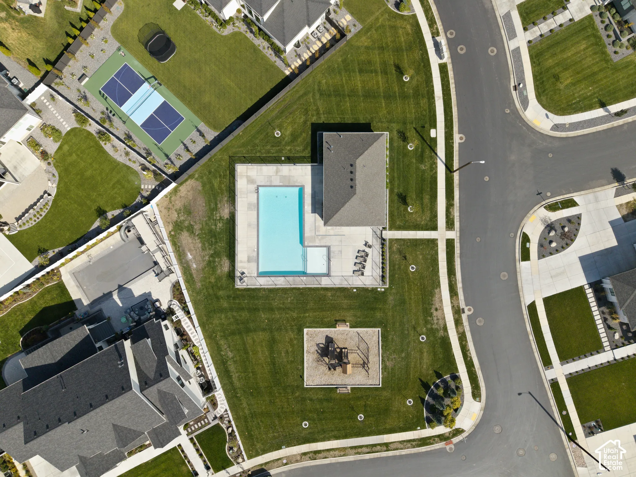 Community amenities featuring a swimming pool with surrounding patio, green space, and a playground