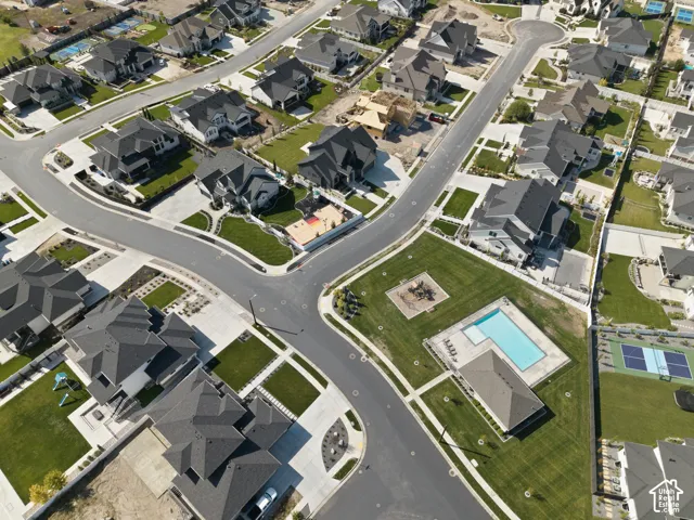 Community with residential properties, paved streets, manicured lawns, a swimming pool, and tennis courts