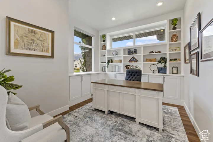 Built-in shelving with lower cabinetry, wood-finish flooring, recessed lighting, and a large window