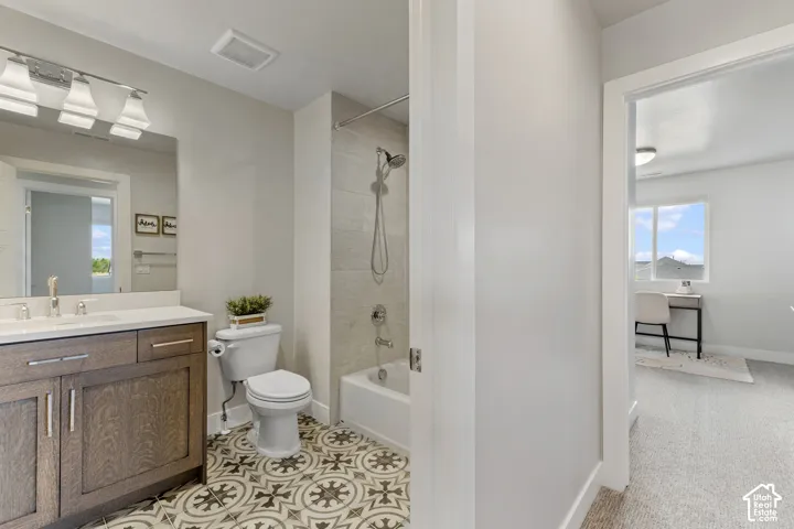 Spa-inspired primary bathroom featuring a wood-finish vanity with dual sinks, polished countertop, and contemporary lighting