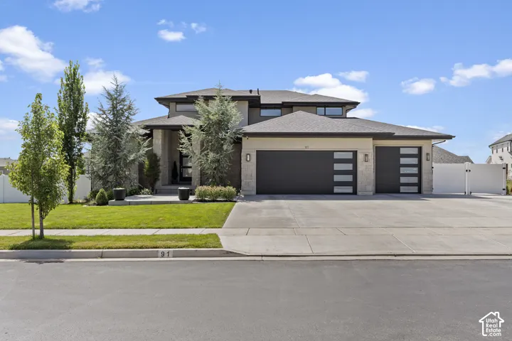 Modern two-story residence showcasing a contemporary architectural design with a taupe and charcoal exterior, multiple gabled rooflines, and horizontal siding accents