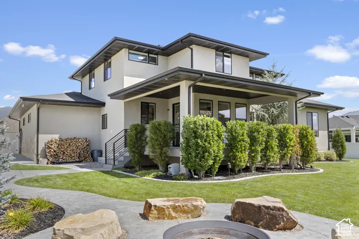 Modern two-story residence featuring a clean-lined exterior with mixed material cladding, expansive front-facing windows, and a covered entry portico