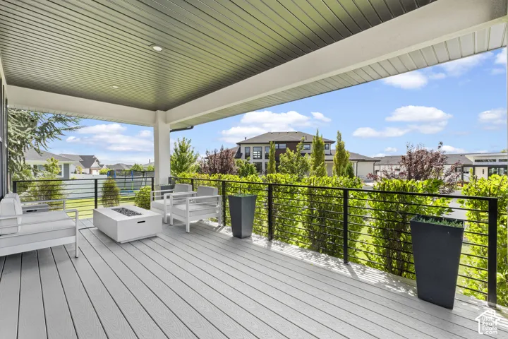 Expansive composite deck with wood-finish flooring and a covered pavilion featuring a corrugated metal ceiling