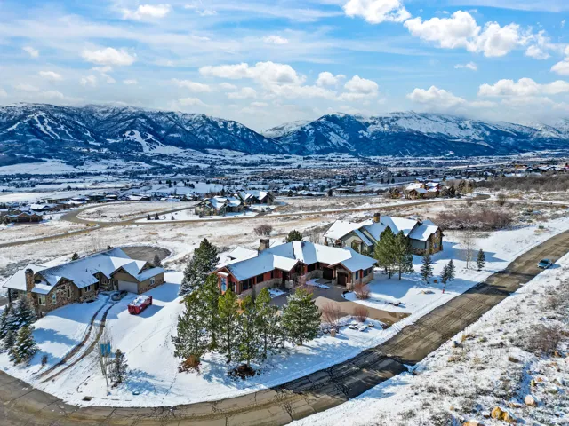 Expansive properties featuring stone and siding exteriors, multi-car garages, and extensive landscaping