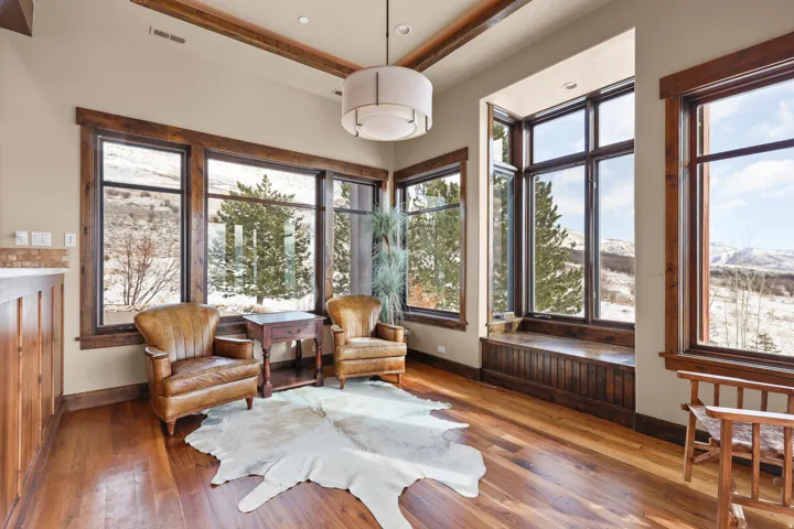 Wood-finish flooring, exposed wood beams, and a large window bench