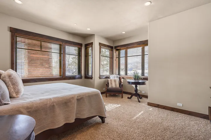 North bedroom. Recessed lighting, wood-trimmed windows with blinds, and textured wall finish