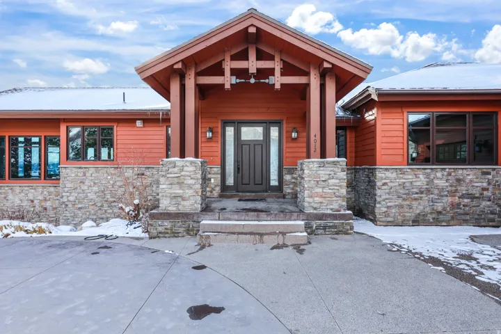 Stone veneer accents the exterior, complemented by wood-tone siding