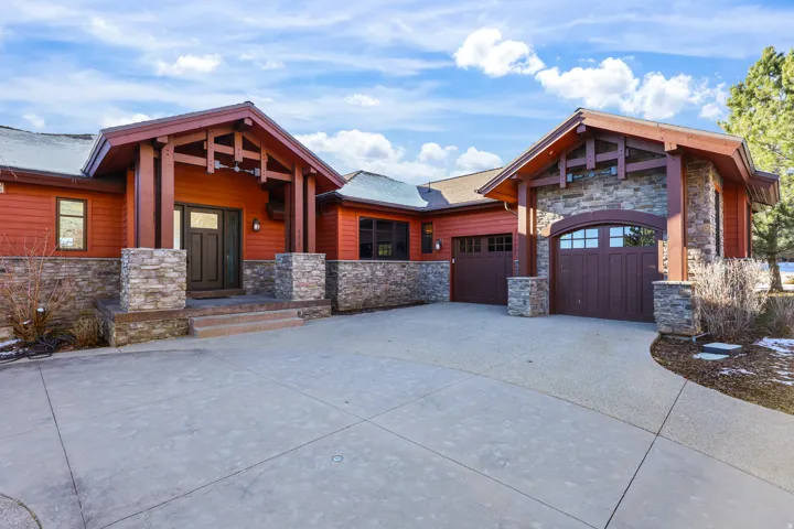Craftsman-style exterior with wood siding, stone accents, and exposed structural timbers