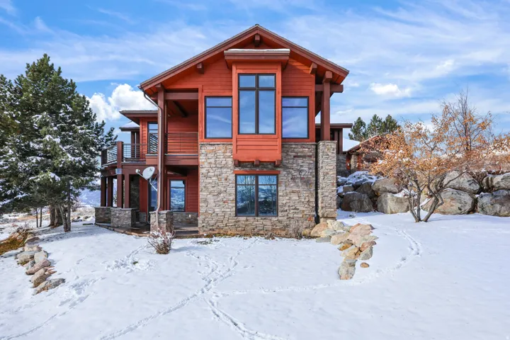 Exterior featuring wood siding, stone cladding, and multiple large windows