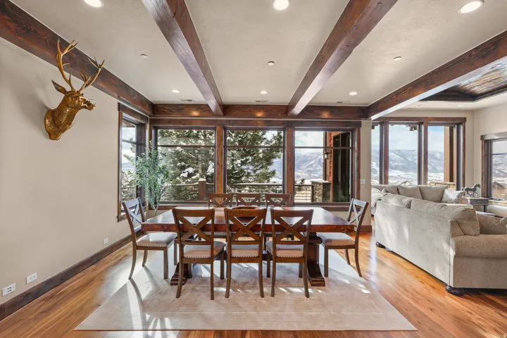 Hardwood flooring, exposed ceiling beams, recessed lighting, and expansive windows