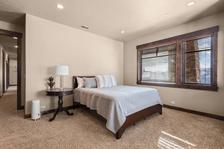 North bedroom. Recessed lighting, wood-trimmed windows with blinds, and textured carpeting