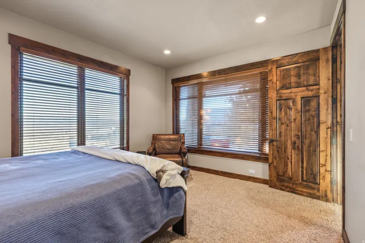 South bedroom. Carpeting throughout, recessed lighting, and rich wood-finish trim around windows and doorway