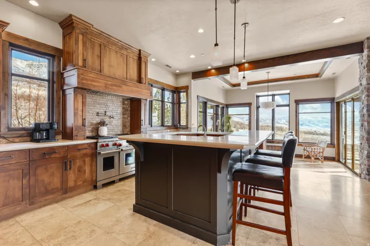 Gourmet kitchen with custom wood cabinetry, a large center island, and stainless steel range