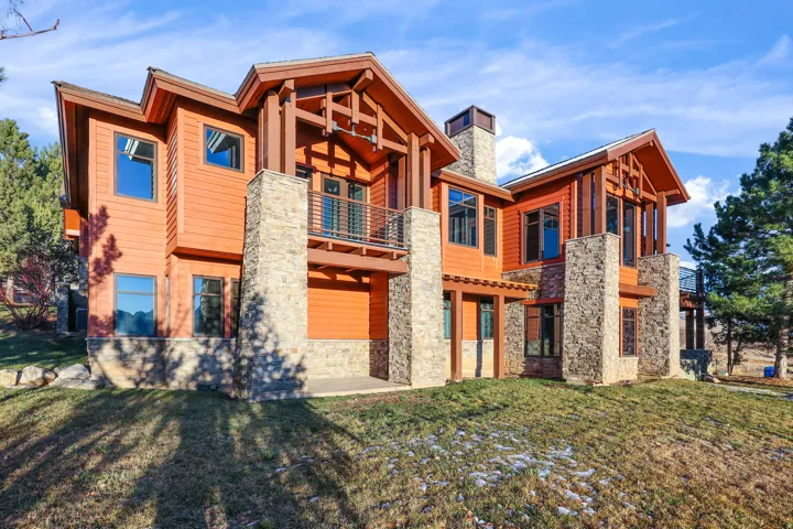 Wood-sided exterior with stone accents, multiple balconies, and visible structural beams