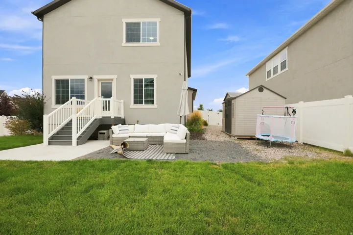 Poured concrete patio with white railing stairs and a stucco exterior
