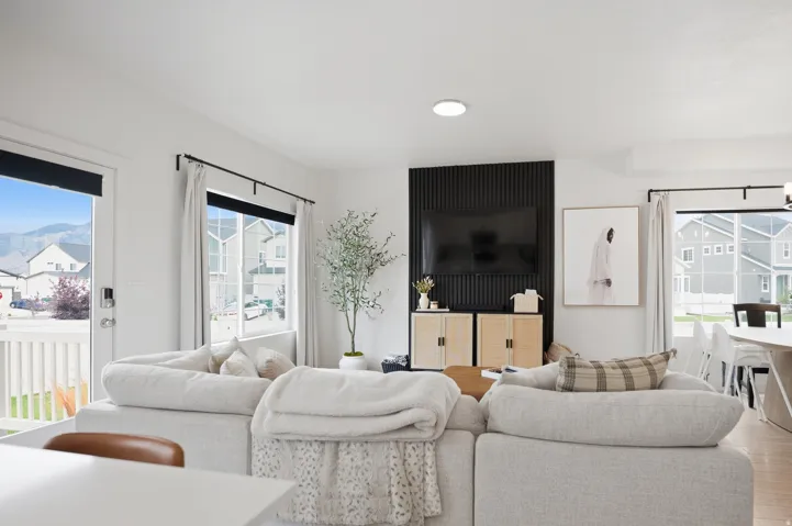 Open-concept living area featuring light wood-finish flooring, white walls, and a recessed ceiling light