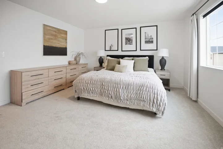 Neutral-toned carpeting, white walls, and a large window with white trim