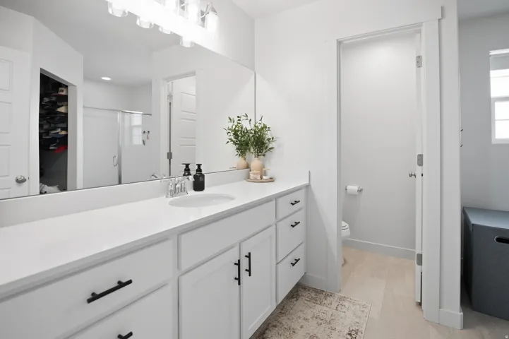 Double vanity with white cabinetry, matte black hardware, and an integrated sink