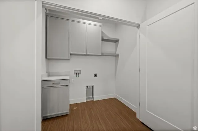 Compact utility area featuring LVP flooring, light-toned cabinetry, and a countertop