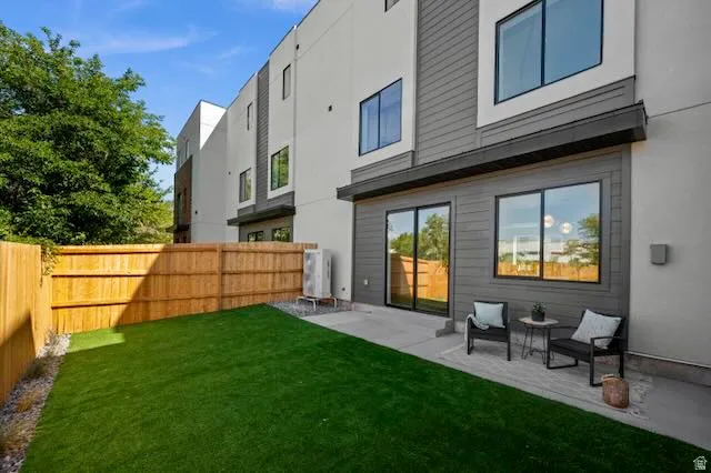 Private backyard featuring artificial turf and concrete patio