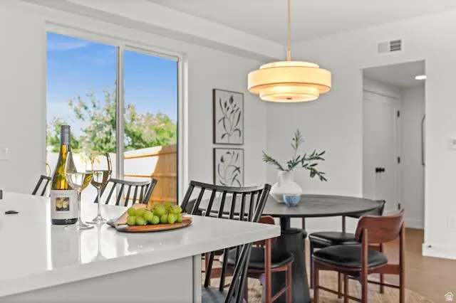 Quartz countertop island, expansive sliding glass door, tiered pendant lighting, and LVP flooring