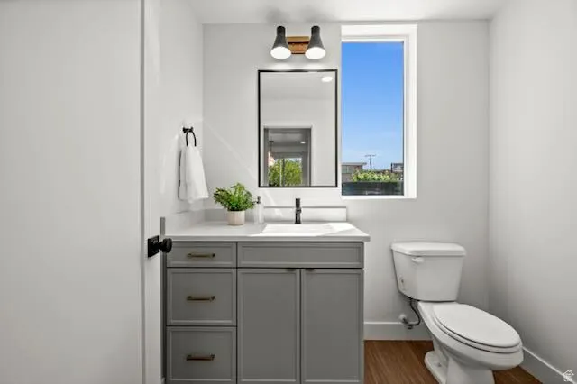 Modern vanity with a light gray finish, solid surface countertop, integral sink, and matte black faucet