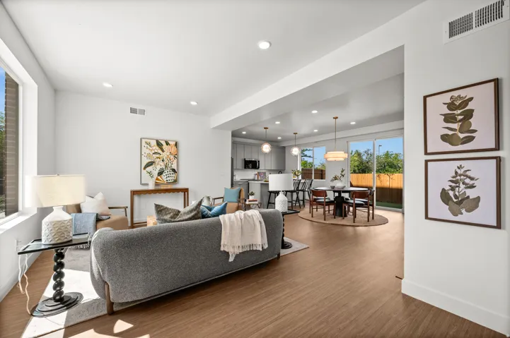 Open-concept living space with LVP flooring, recessed lighting, and large windows