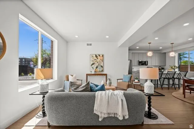 Open-concept living space featuring wood-finish flooring, recessed lighting, and large windows