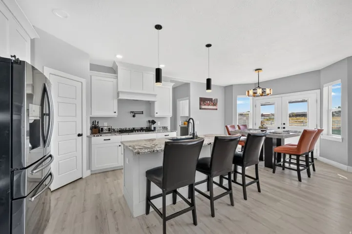Kitchen featuring white cabinetry, a kitchen island with seating, granite countertops, and wood-finish flooring