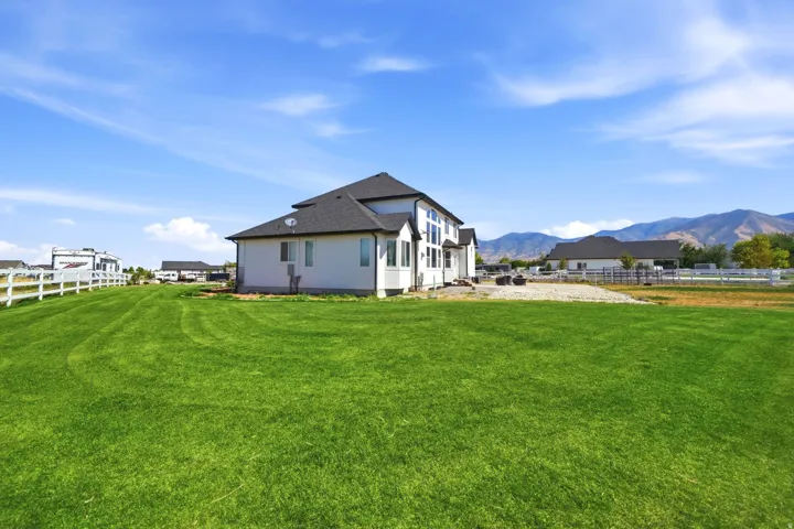 Expansive green lawn with a white fence border