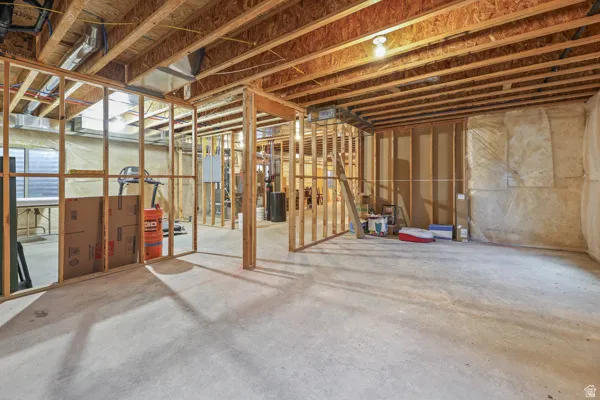 Unfinished basement with concrete flooring and exposed wood framing