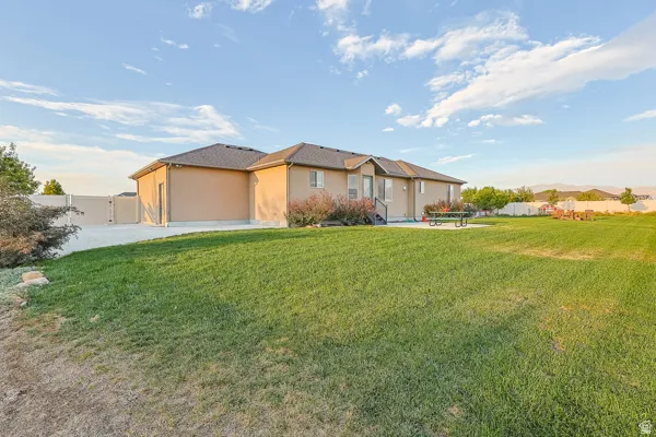Expansive grassy yard with a paved patio area