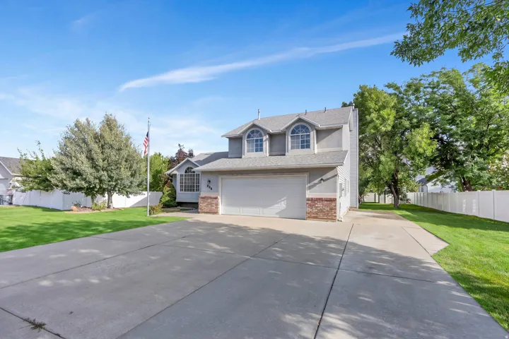 Two-story residence featuring a gray exterior, brick accents, and a two-car garage