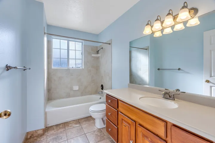 Bathroom featuring a single vanity with wood cabinetry, a white countertop, and a white undermount sink