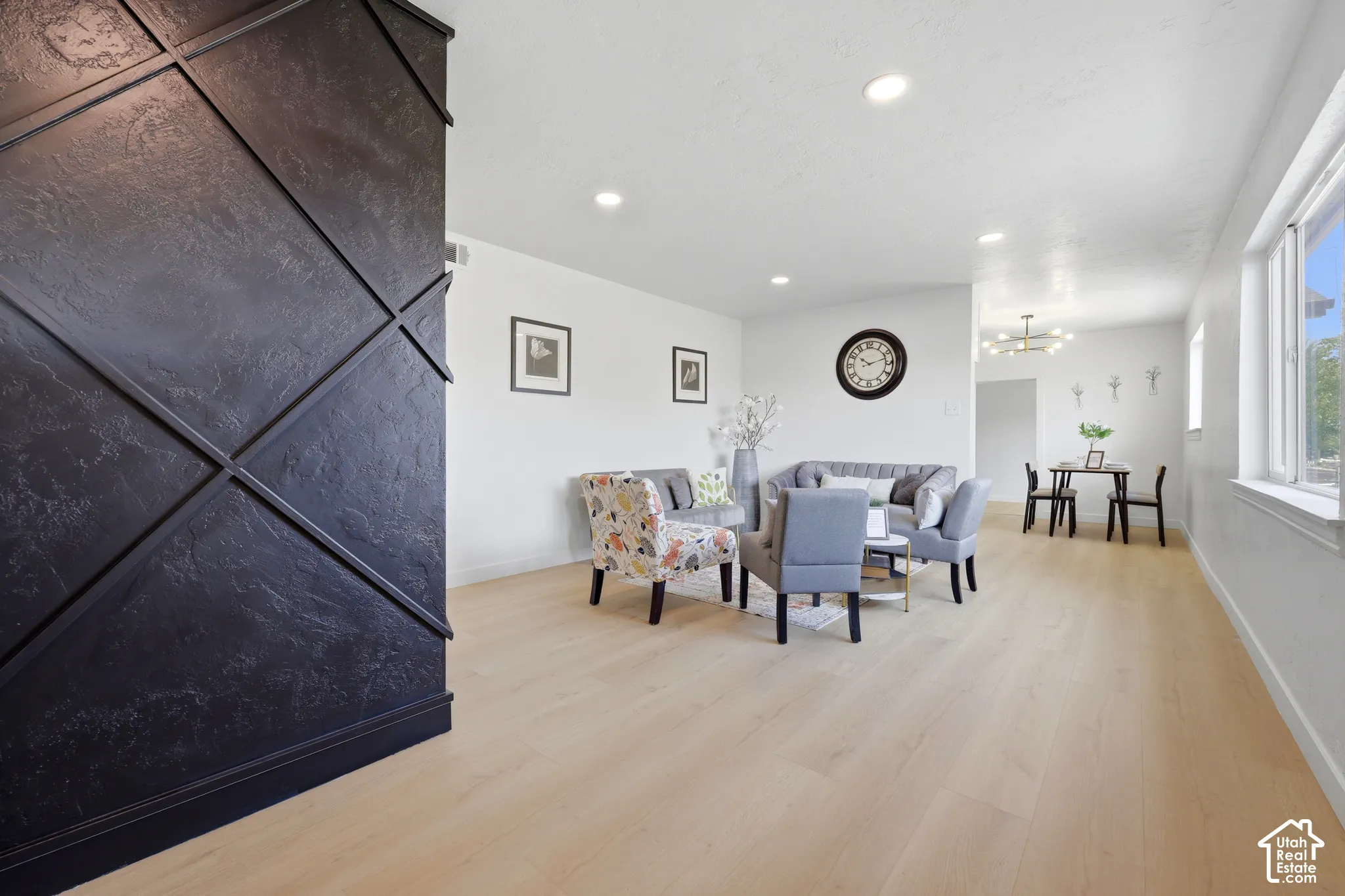 Light wood-finish flooring throughout, recessed ceiling lighting, and abundant natural light from multiple windows