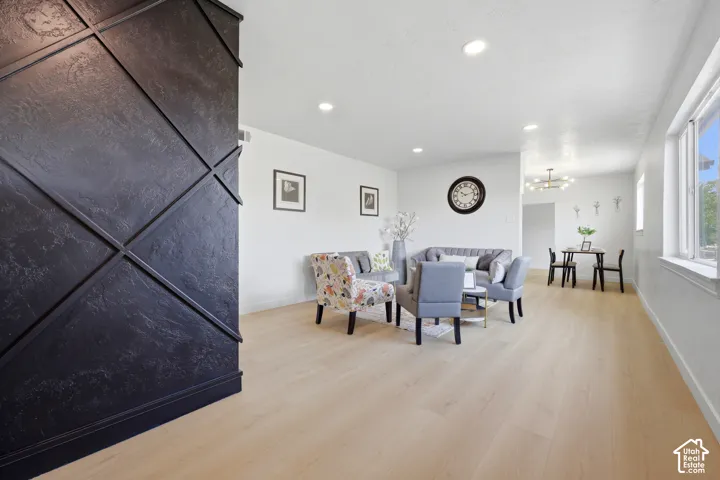 Light wood-finish flooring throughout, recessed ceiling lighting, and abundant natural light from multiple windows