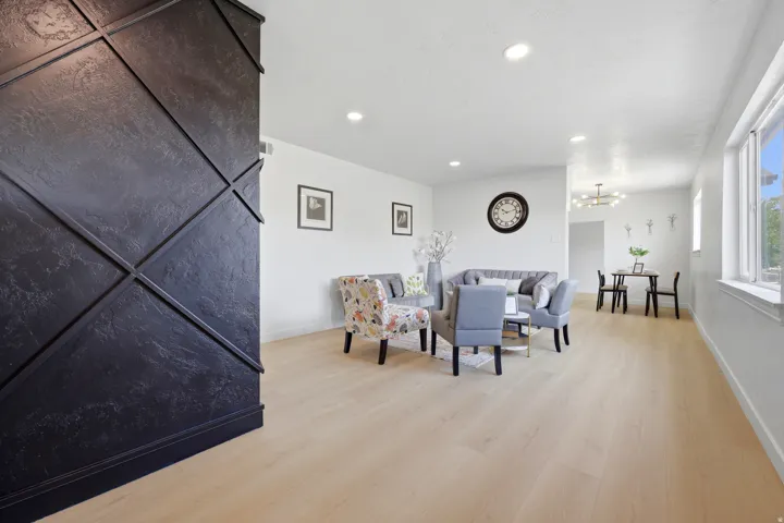 Light wood-finish flooring throughout, recessed ceiling lighting, and abundant natural light from multiple windows